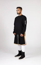 Load image into Gallery viewer, Black Male model wears mens black and gold casual summer fashion long shorts silk lined for our menswear blog and magazine photography side view